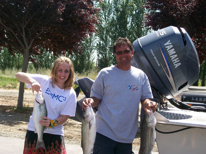 Karl Pflum and daughter, Erin, holding up large bass fish after a great fishing day