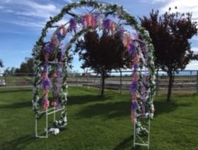 Pflum Pfun Rentals white wedding arch covered in flowers 